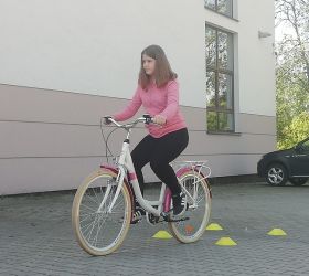 Dziewczynka jedzie na rowerze po wyznaczonej trasie