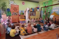 2. Edukator prezentuje dzieciom strój pszczelarza, dzieci siedzą w kółku na dywanie.