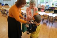 5. Dwie nauczycielki wręczają nagrodę dziecku