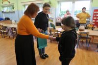 8. Dwie nauczycielki wręczają nagrodę dziecku