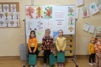 13. Troje dzieci stoi na tle dekoracji