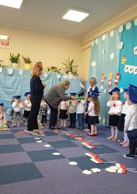 11. . Pani dyrektor dokonuje ołówkiem pasowania dzieci na przedszkolaka