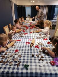 1. Dzieci wałkują ciasto i wycinają foremkami świąteczne pierniczki.