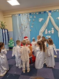 17. Święty Mikołaj rozdaje dzieciom prezenty.