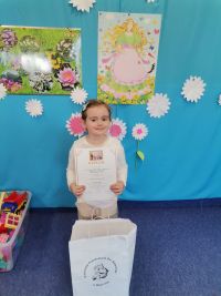 5.Laureatka konkursu pozuje do zdjęcia z nagrodą i dyplomem.