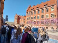 9 wycieczkowicze poruszają się ulicami starego miasta w Toruniu