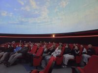 12 wycieczkowicze w planetarium